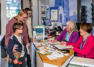 Family visiting museum and speaking to museum reception