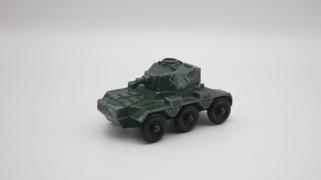 A small worn tank with flaking green paint made from metal to be used as a toy (1960s)