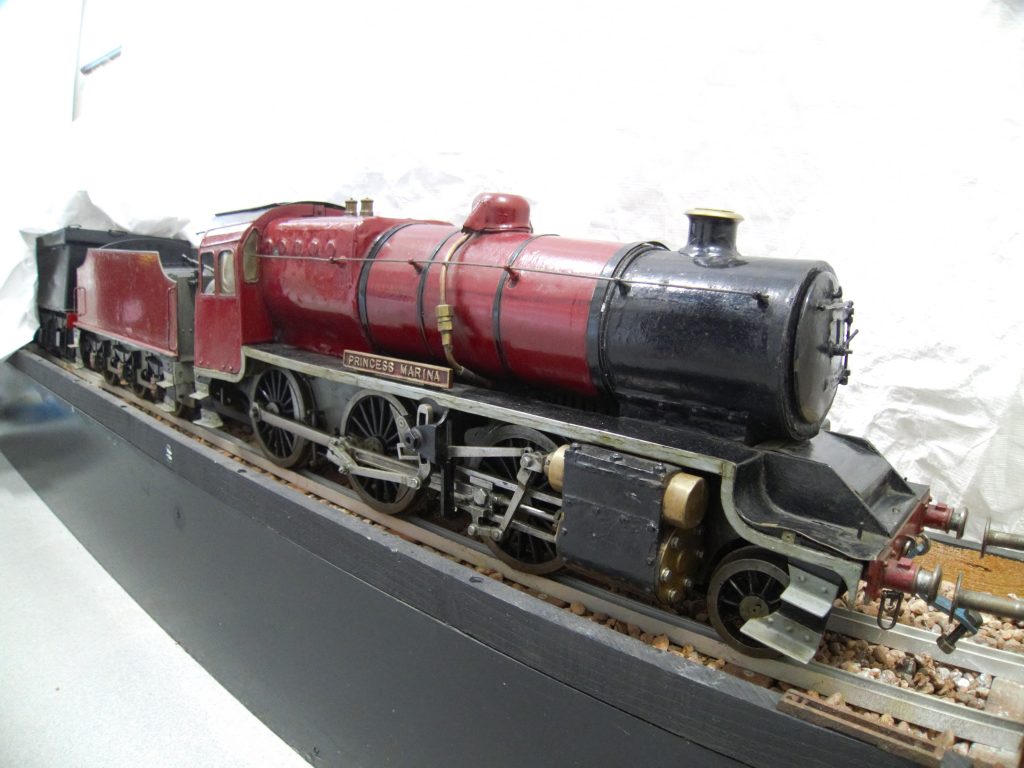 Red model steam train against a white background
